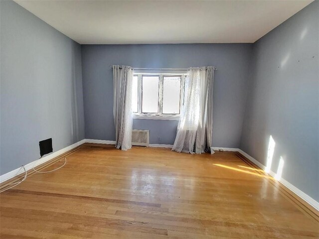 empty room with light hardwood / wood-style flooring