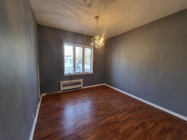 unfurnished room with dark hardwood / wood-style floors and a chandelier