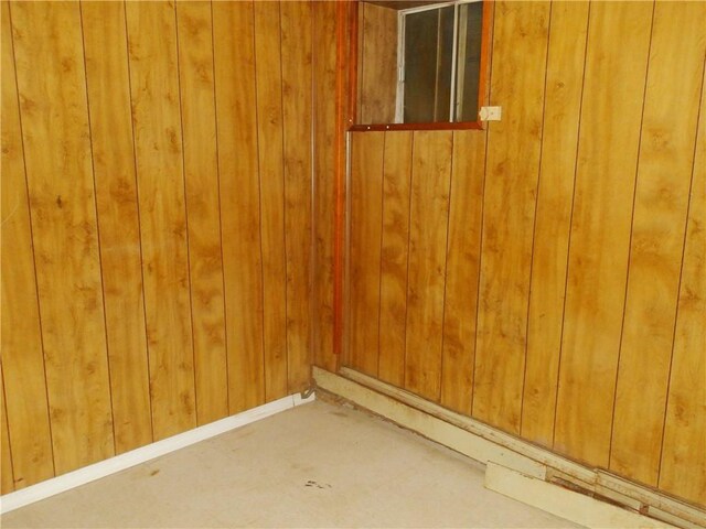 unfurnished room featuring wood walls