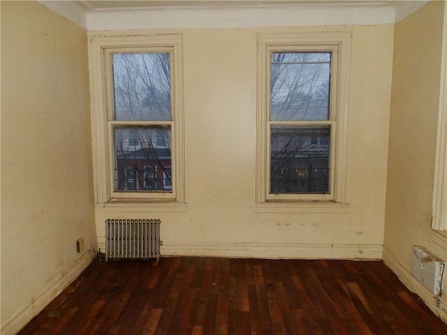 spare room featuring radiator and dark wood-type flooring