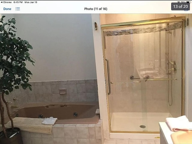 bathroom featuring shower with separate bathtub