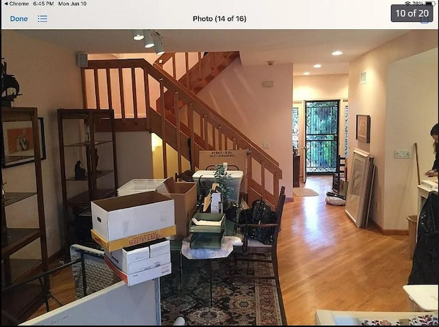 living room featuring baseboards, light wood finished floors, stairway, and recessed lighting