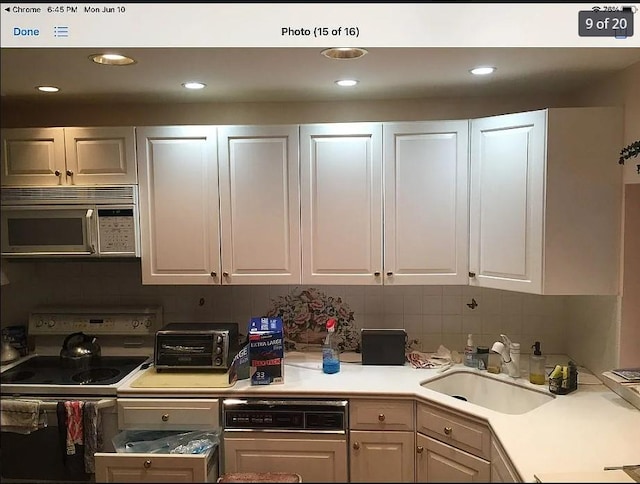 kitchen with white electric range, sink, and white cabinets