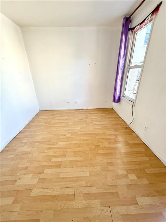 unfurnished room featuring light wood finished floors and baseboards