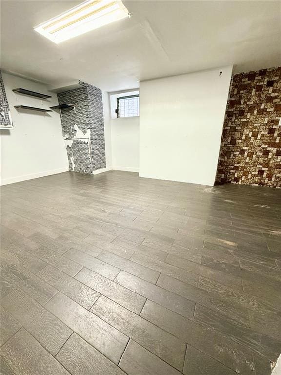 below grade area featuring brick wall and wood finished floors