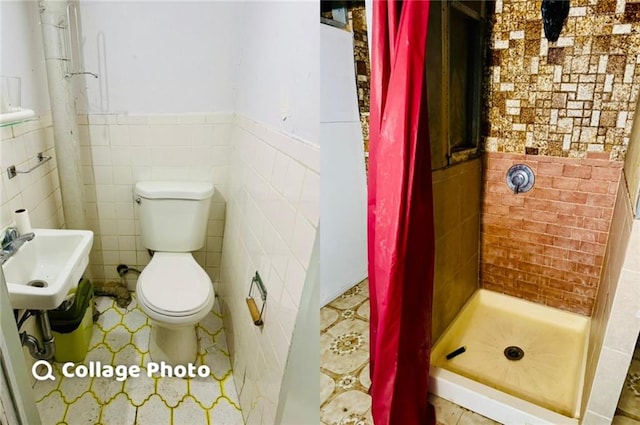 bathroom with a shower stall, a wainscoted wall, toilet, a sink, and tile walls