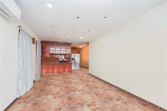 interior space featuring a wall mounted AC and white fridge with ice dispenser