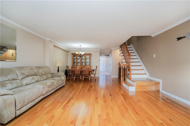 living room featuring hardwood / wood-style floors, a textured ceiling, ornamental molding, and a notable chandelier