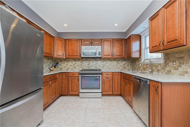 kitchen featuring stainless steel appliances, light stone counters, tasteful backsplash, and sink