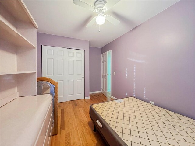 bedroom featuring ceiling fan, light wood-type flooring, and a closet