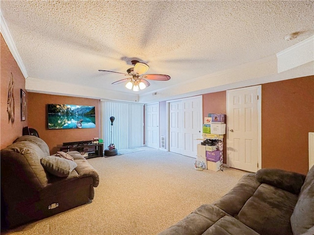 carpeted living room featuring a textured ceiling, ceiling fan, and crown molding