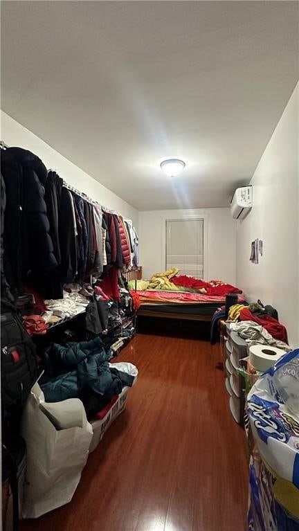 bedroom featuring hardwood / wood-style flooring and a wall unit AC