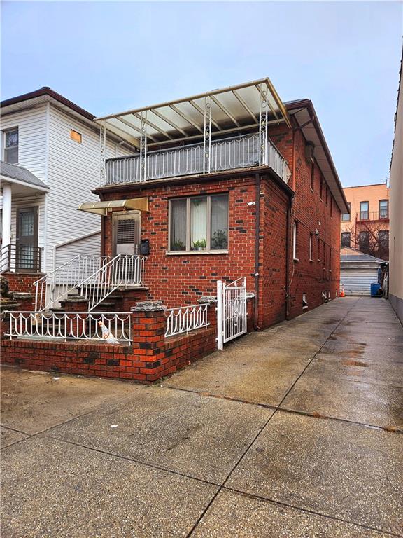 view of front of property featuring brick siding and a balcony