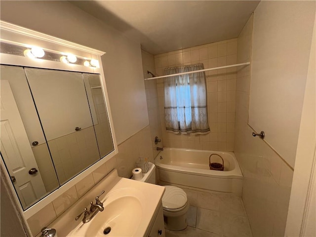 full bathroom featuring tile patterned flooring, tiled shower / bath combo, toilet, and vanity