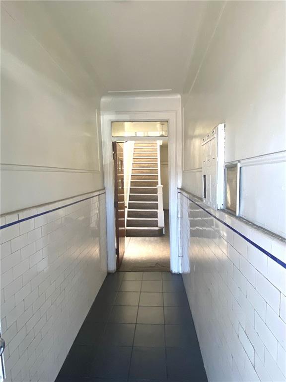 hall featuring dark tile patterned floors