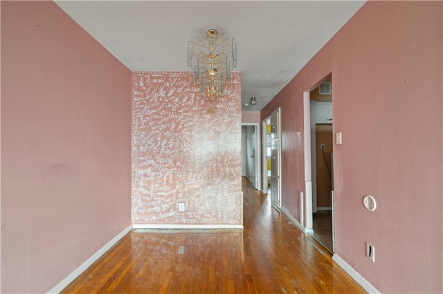 unfurnished dining area with baseboards and wood finished floors