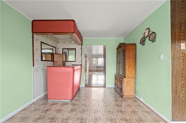 kitchen featuring wallpapered walls, an accent wall, baseboards, and crown molding