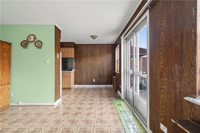 kitchen featuring wood walls, light tile patterned floors, baseboards, and light countertops