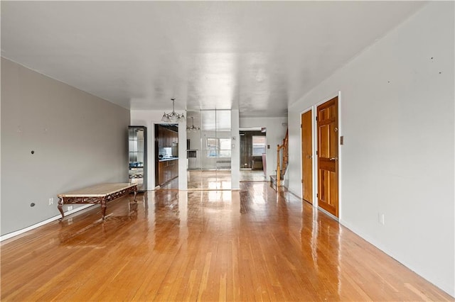 unfurnished living room featuring stairway and wood finished floors