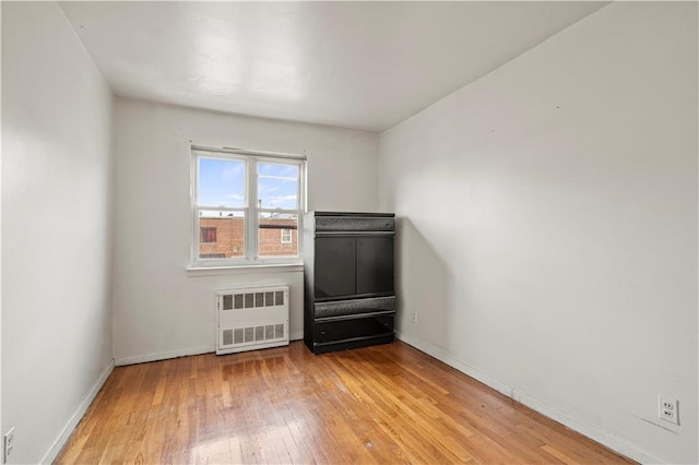 empty room with radiator and light wood-type flooring