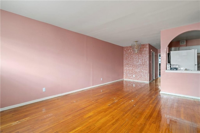 empty room with baseboards and wood finished floors