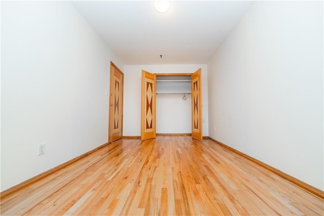 unfurnished bedroom featuring a closet, baseboards, and wood finished floors