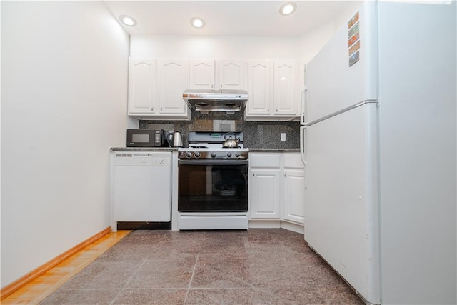 kitchen with dark countertops, backsplash, exhaust hood, white appliances, and white cabinetry