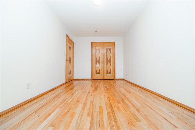 unfurnished room featuring light wood-type flooring and baseboards