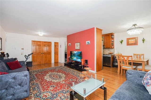 living room with a chandelier and light wood-type flooring