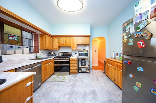 kitchen featuring decorative backsplash, sink, and stainless steel appliances