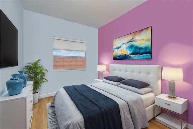 bedroom with light wood-style flooring and baseboards