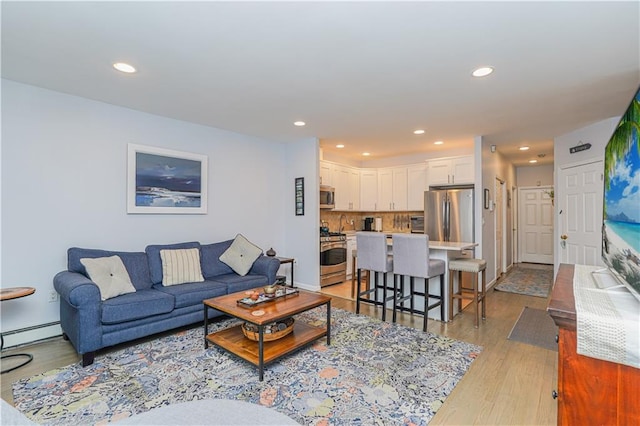 living room featuring baseboards, light wood-type flooring, and recessed lighting