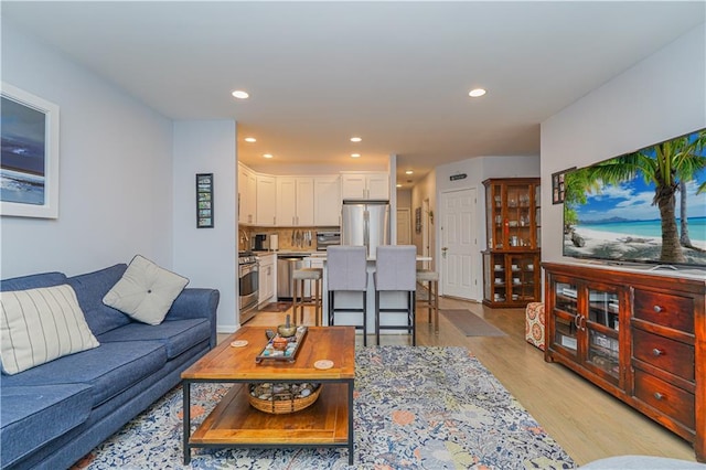 living room featuring a toaster, light wood finished floors, and recessed lighting