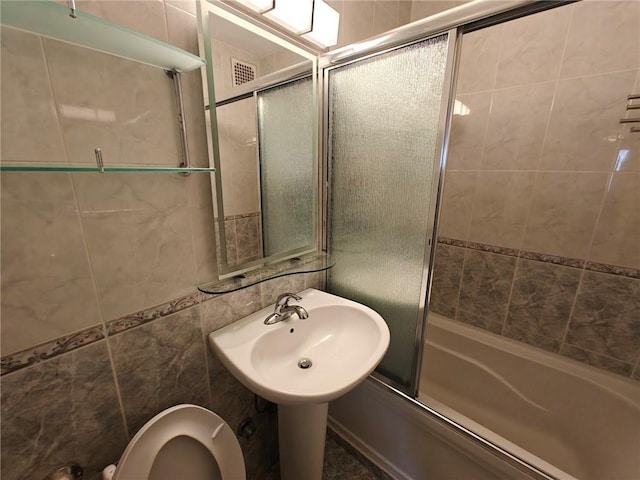 bathroom with enclosed tub / shower combo, a sink, visible vents, and toilet