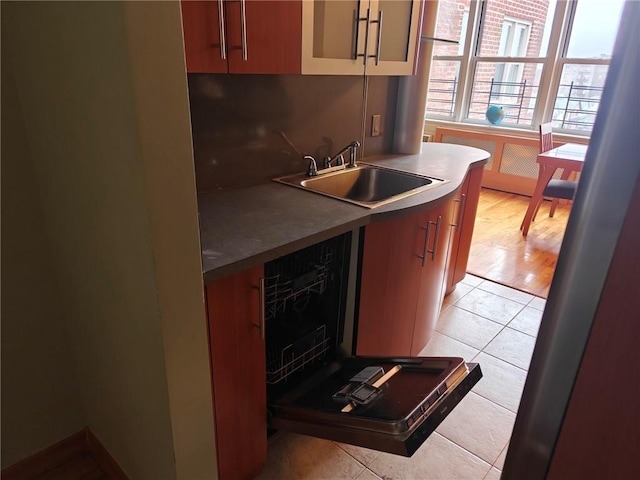 kitchen featuring light tile patterned floors, a sink, and decorative backsplash