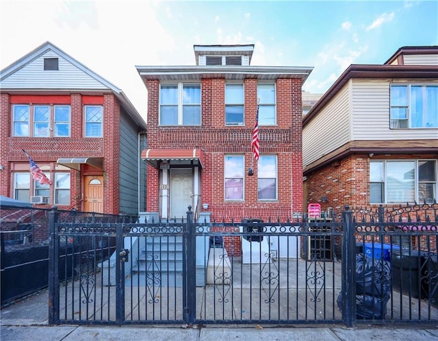 american foursquare style home featuring a fenced front yard and brick siding