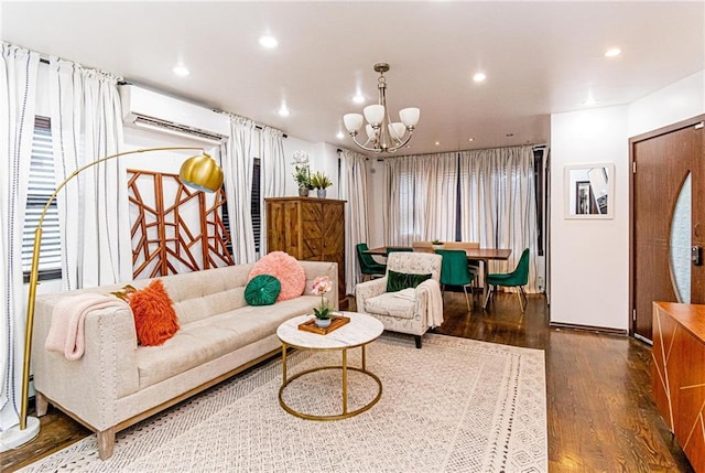 living room with dark wood-type flooring, a wall unit AC, and a chandelier