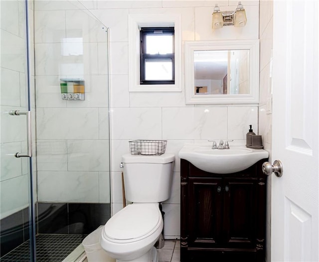 bathroom featuring vanity, toilet, a shower with shower door, and tile walls