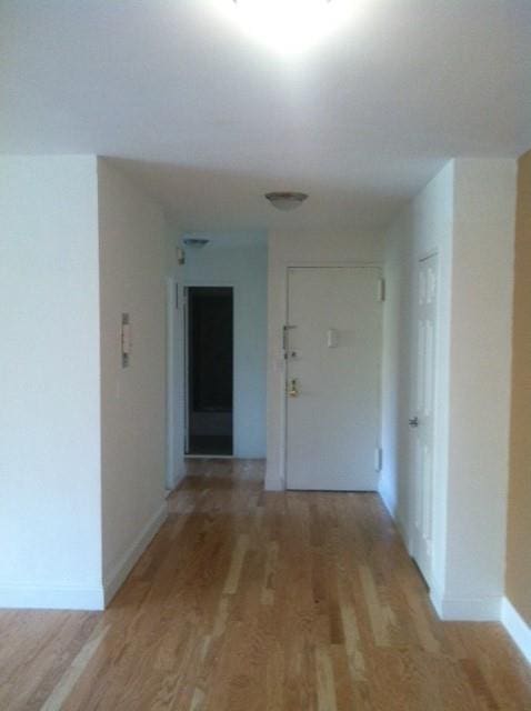 hallway with baseboards and light wood-type flooring