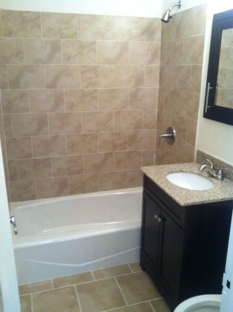 bathroom featuring tile patterned flooring, vanity, and tiled shower / bath combo