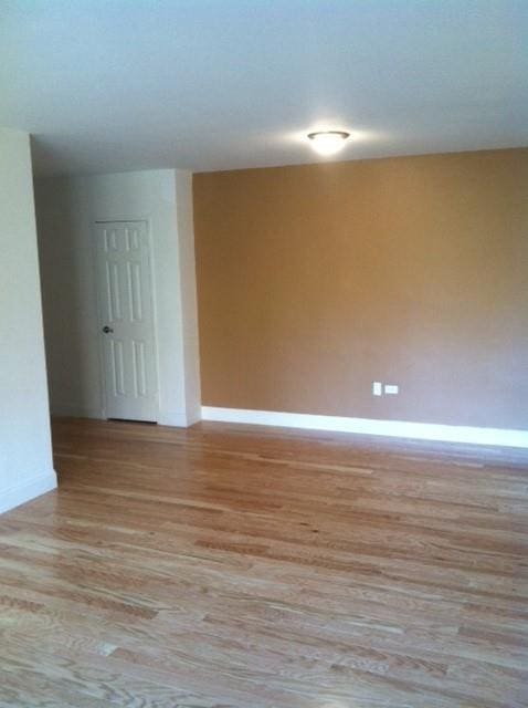 empty room featuring light wood-style flooring and baseboards