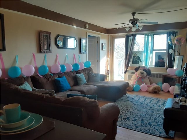 living area featuring a ceiling fan and wood finished floors