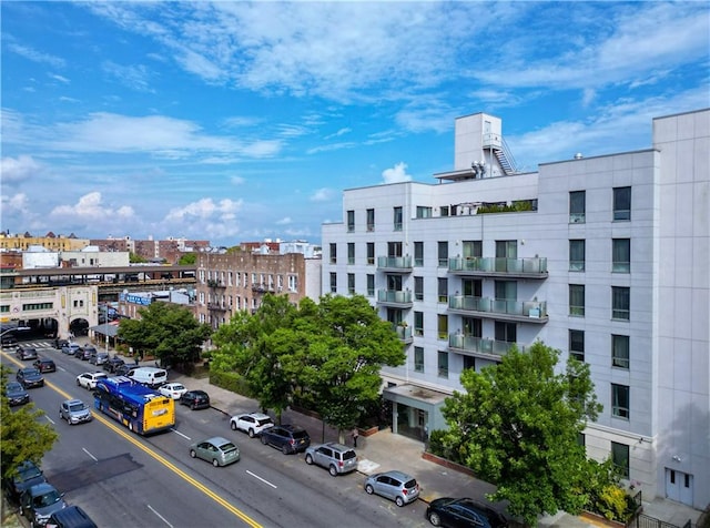 view of building exterior with a city view and uncovered parking