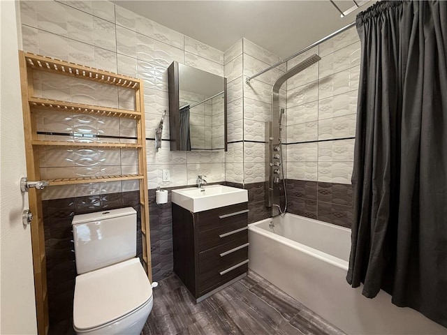 bathroom with toilet, tile walls, shower / bath combo, and vanity