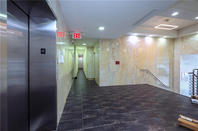 hall with recessed lighting, elevator, and an upstairs landing