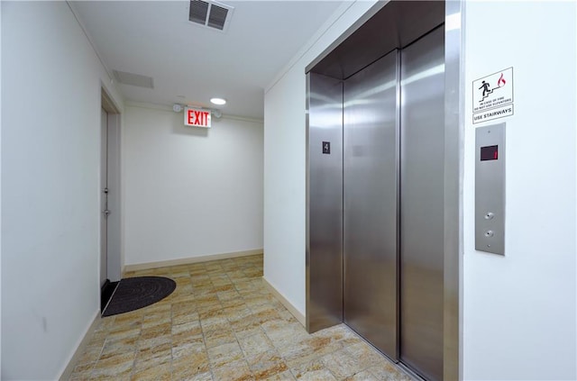 hallway with visible vents, elevator, baseboards, and stone finish flooring