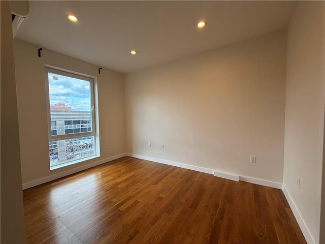 unfurnished room with recessed lighting, baseboards, and wood finished floors