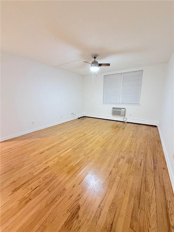 unfurnished room with light hardwood / wood-style floors, a wall unit AC, and ceiling fan