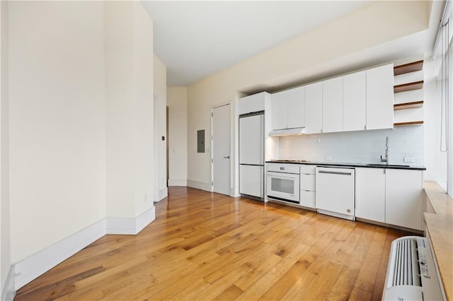 kitchen featuring sink, white appliances, light hardwood / wood-style floors, and white cabinets