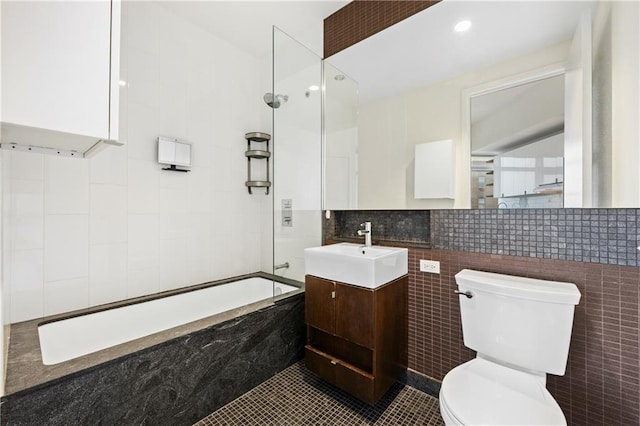 bathroom featuring toilet, vanity, tile walls, shower / bathing tub combination, and tile patterned floors